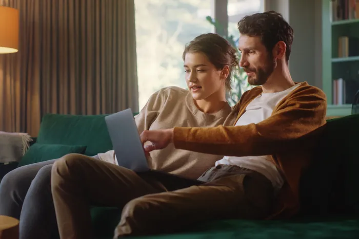 A couple reviewing financing options together on a laptop at home