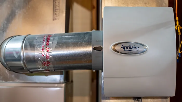 An Aprilaire whole-house humidifier mounted on a heating duct